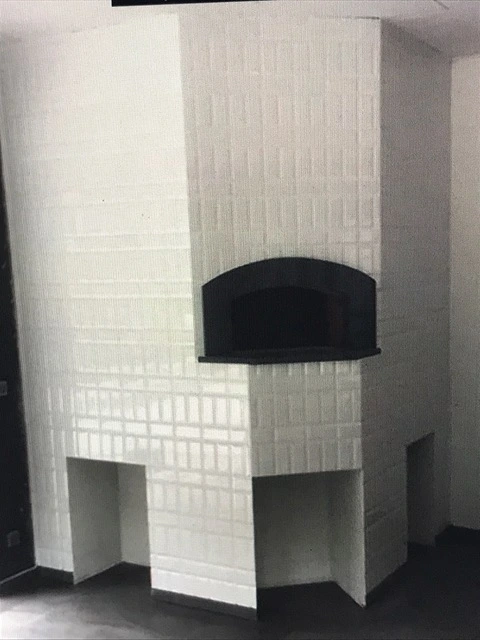Moderne pizzaovn beklædt med hvide klinker for et rent og eksklusivt look.